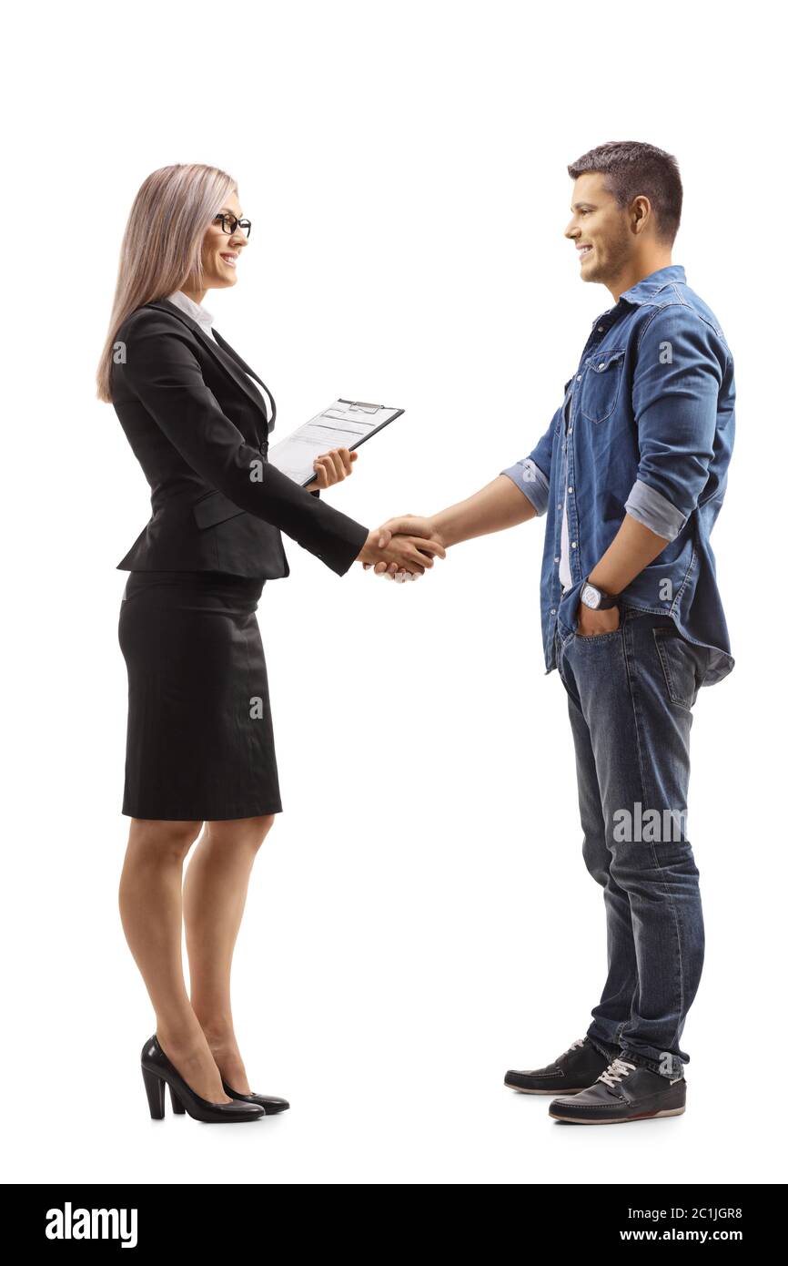 Full length profile shot of a businesswoman shaking hands with a causal young man isolated on white background Stock Photo