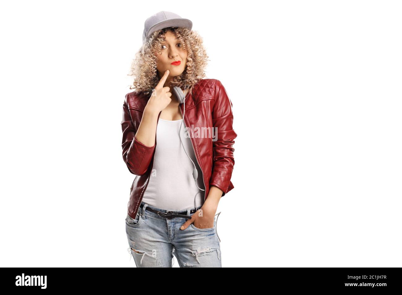 Young woman with a curly blond hair and a cap wearing a red leather jacket with an ignorant expression isolated on white background Stock Photo