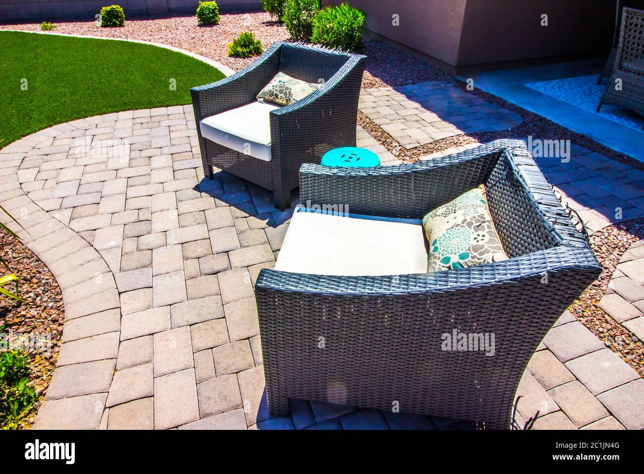Two Outdoor Wicker Arm Chairs On Pavers Patio Stock Photo - Alamy