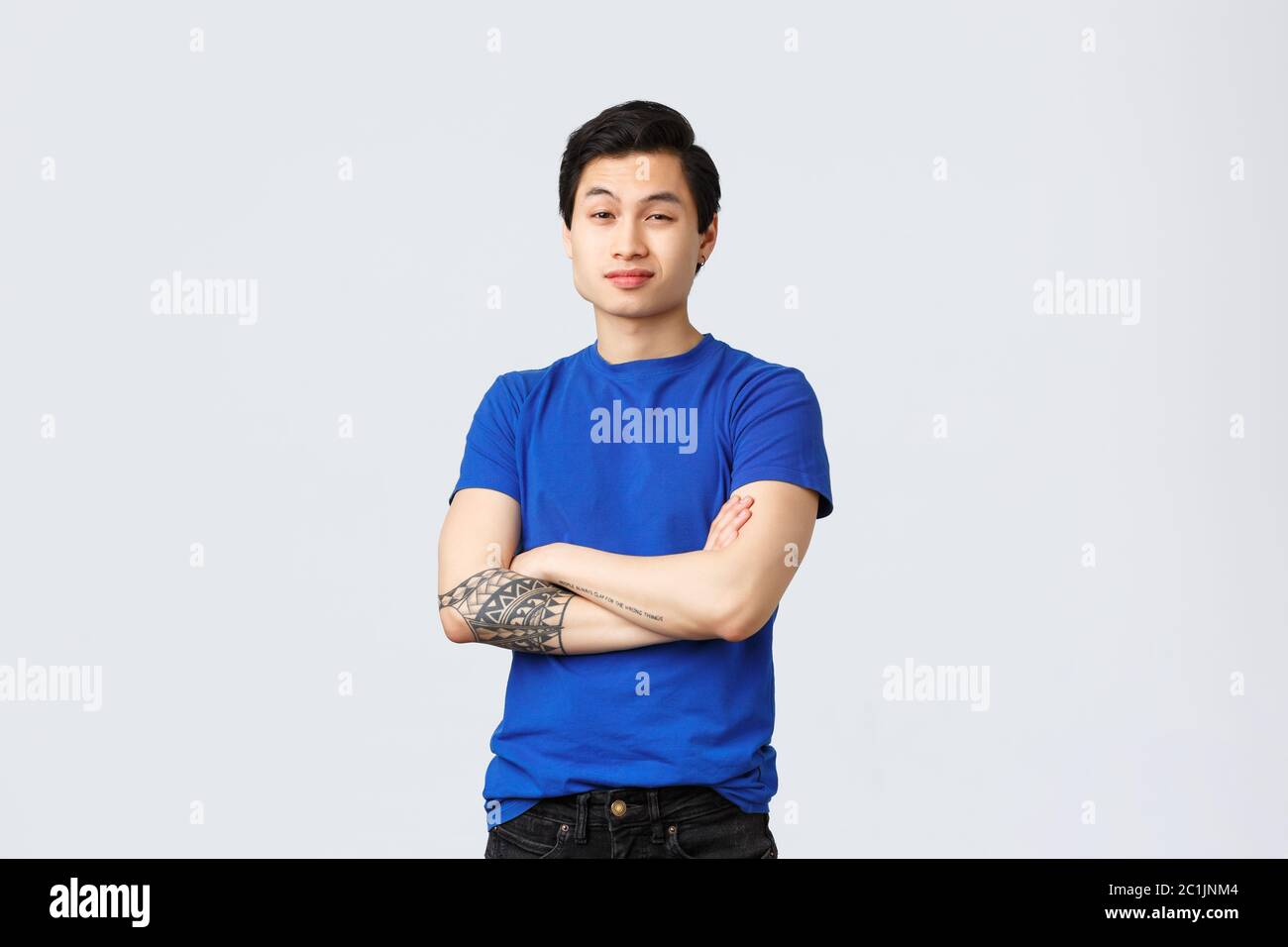 People different emotions, lifestyle and casual concept. Handsome, confident young asian guy in blue t-shirt, cross arms chest and staring at camera Stock Photo