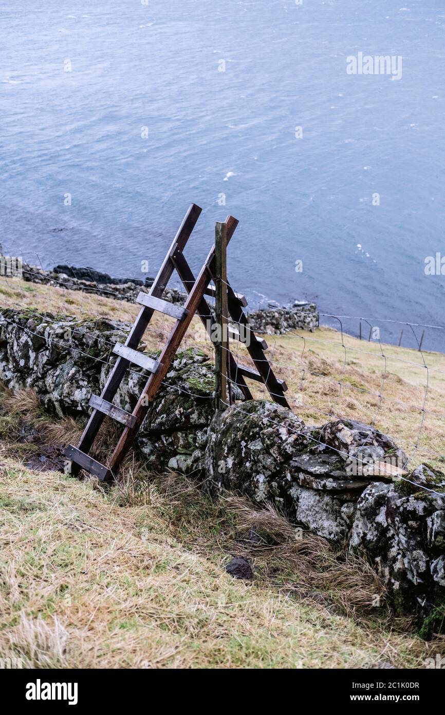 Full length of stair, wall and fence with fjord in background, Faroes Stock Photo