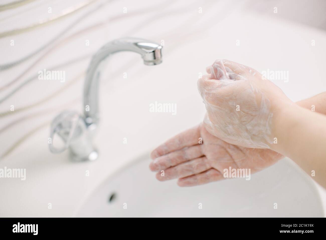 Woman washes her hands by surgical hand washing method. Stock Photo