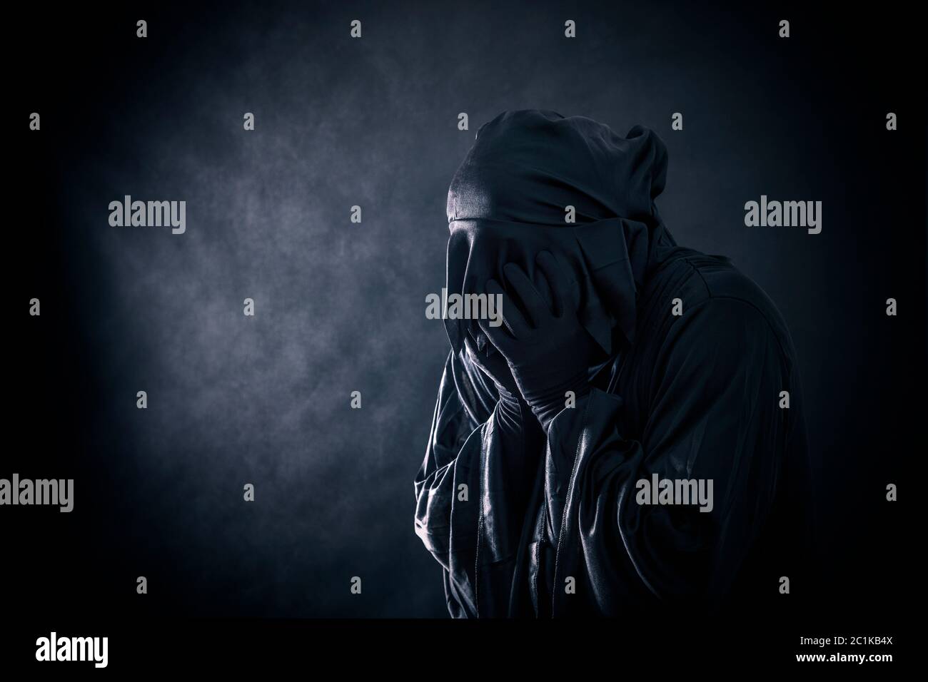 Scary figure in hooded cloak Stock Photo - Alamy