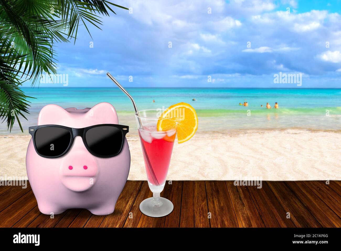 Saving for vacation tourism concept showing sandy beach with piggy bank in fashionable sunglasses with glass of cold orange cocktail juice and copy sp Stock Photo