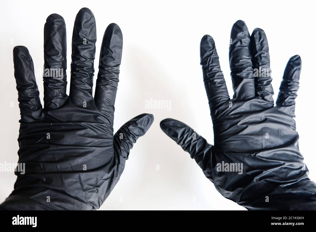 Close up two hands in black gloves on a white background. Stop virus spreading and prevent sickness. Stay safe at home and protect yourself Stock Photo