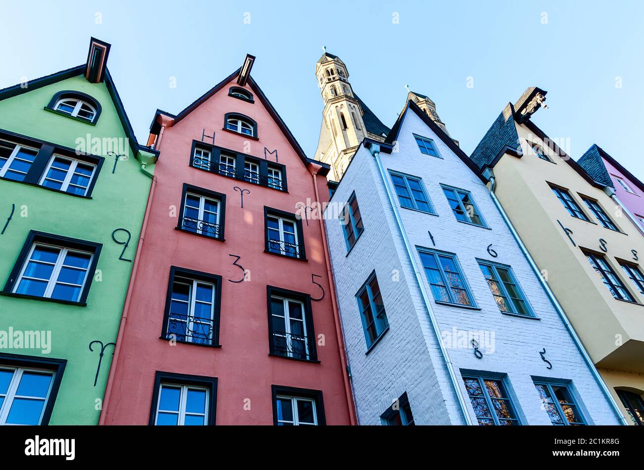 A row of colorful houses at the Rhine promenade in front of the St. Martin Church in Cologne, Germany Stock Photo