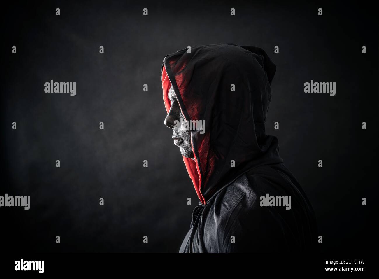 Hooded man in the dark Stock Photo