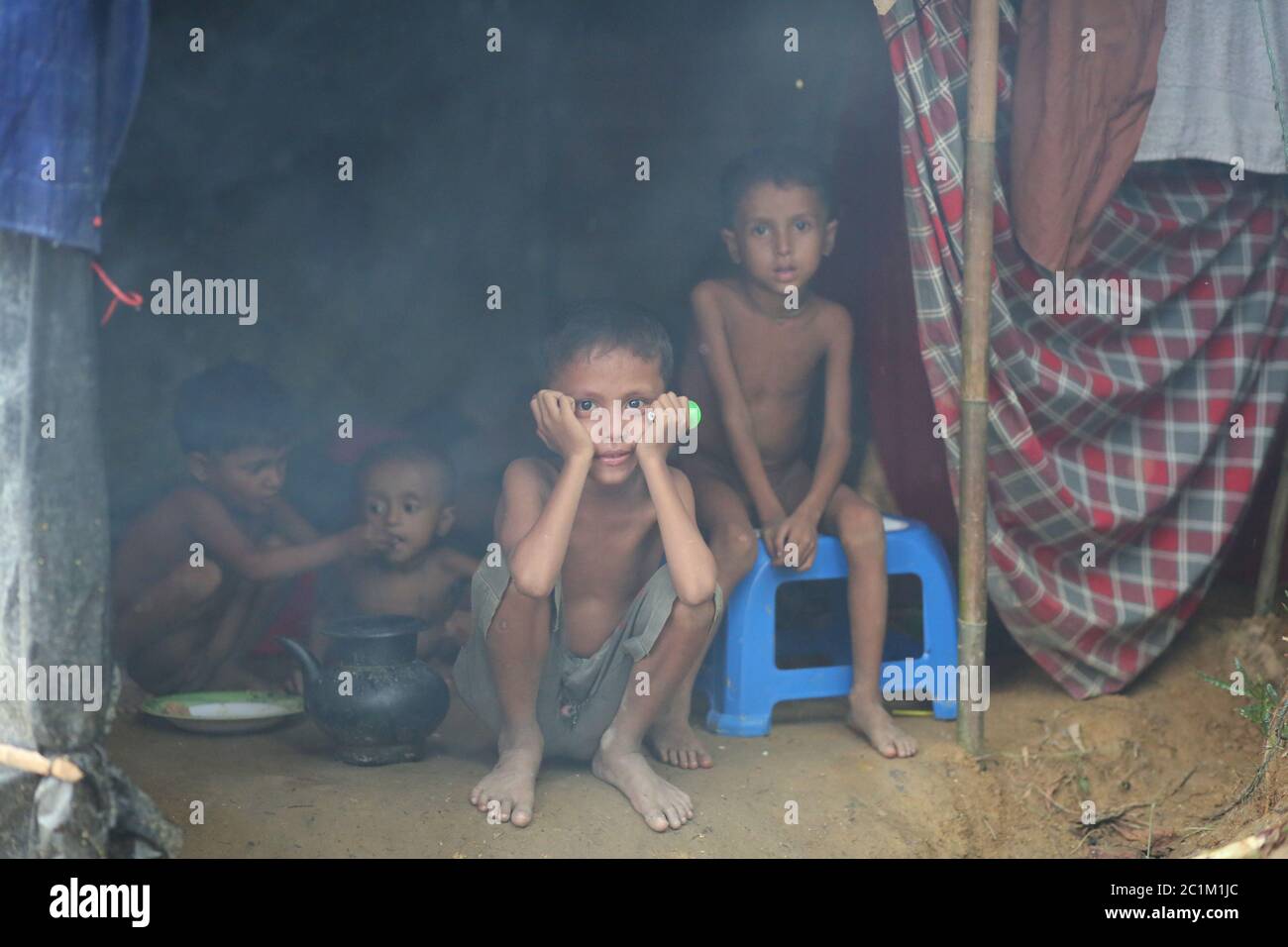 Rohingya children sits in front of a makeshift tent at Kutupalong refugee camp, Bangladesh, Tuesday, Oct. 03, 2017. Stock Photo
