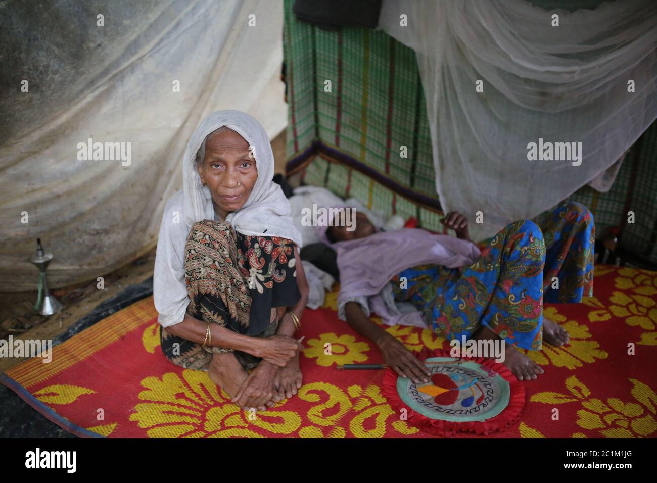 Rohingya womens sits inside a makeshift tent at Kutupalong refugee camp, Bangladesh, Tuesday, Oct. 03, 2017. Stock Photo