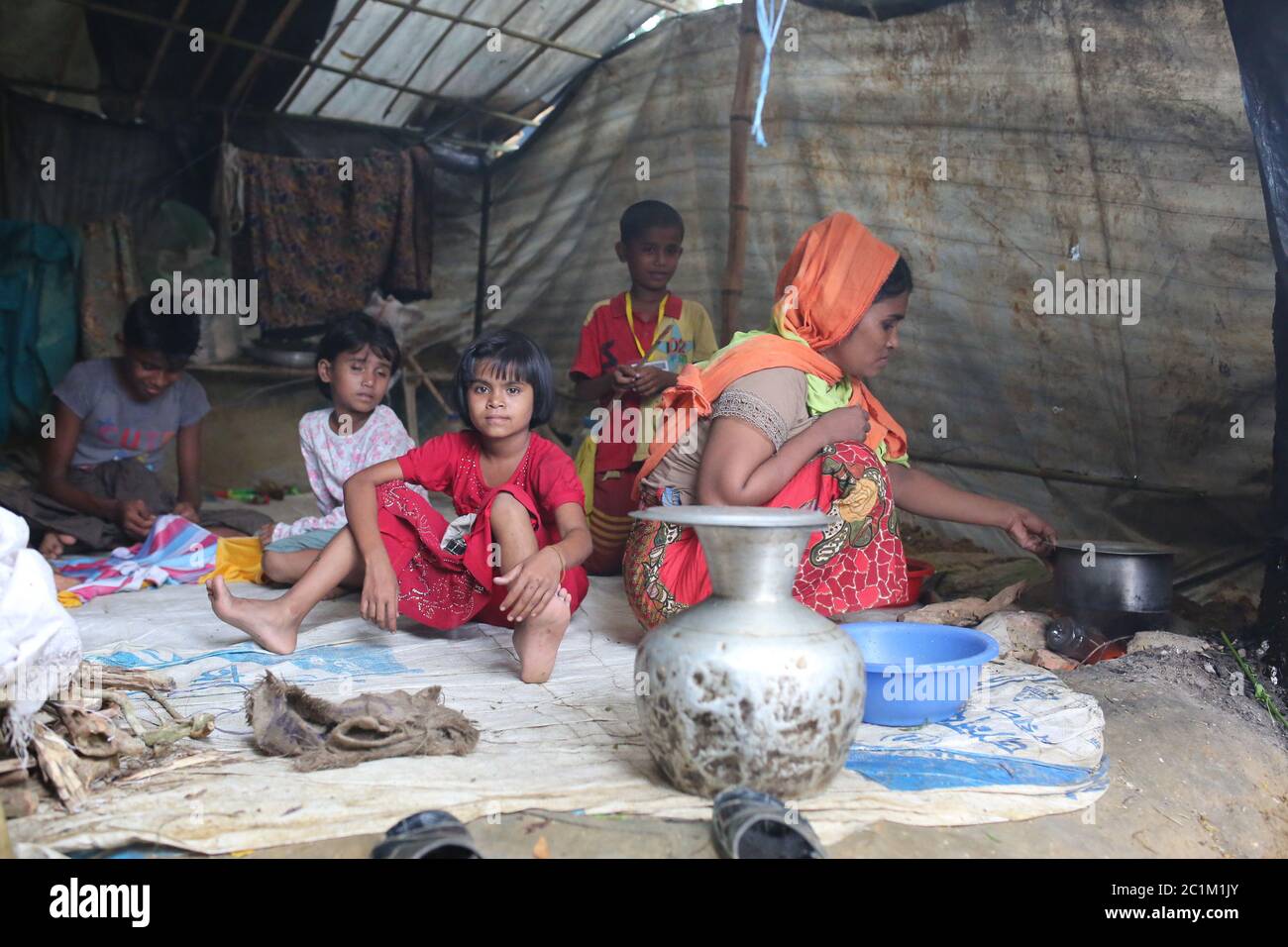 A Rohingya other cooks food inside a makeshift tent at Kutupalong refugee camp, Bangladesh, Tuesday, Oct. 03, 2017. Stock Photo