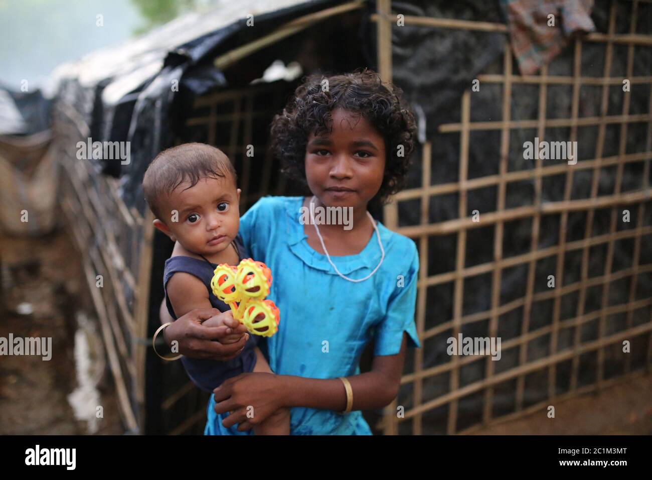 A girl with her lillte sister stands at Kutupalong refugee camp, Bangladesh, Tuesday, Oct. 03, 2017. Stock Photo