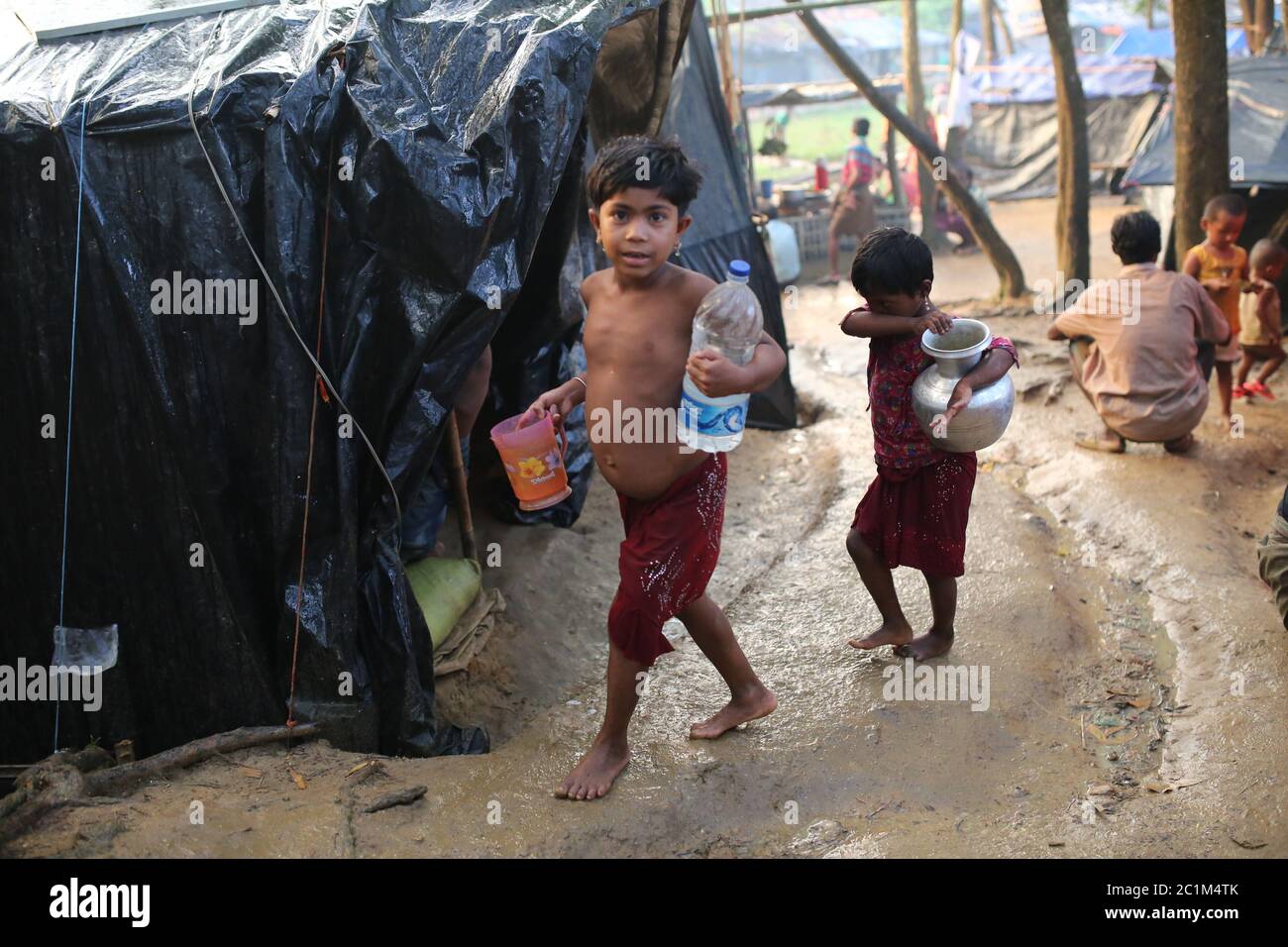 Rohingya children collect drinkable water at Kutupalong refugee camp, Bangladesh, Tuesday, Oct. 03, 2017. Stock Photo