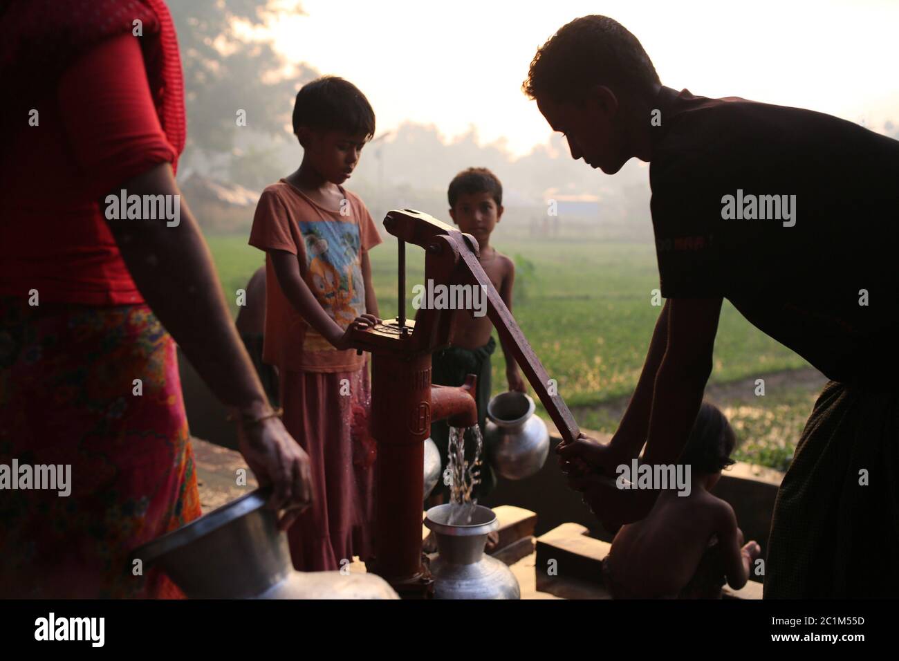 Rohingya people gather to collect drinkable water at Kutupalong refugee camp, Bangladesh, Tuesday, Oct. 03, 2017. Stock Photo