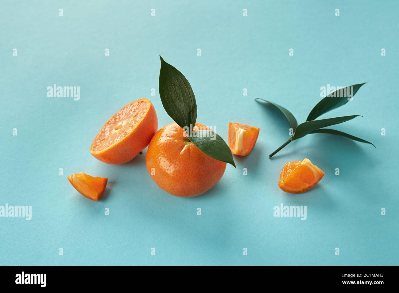 Exotic citrus fruits with green leaves on a blue paper background Stock ...