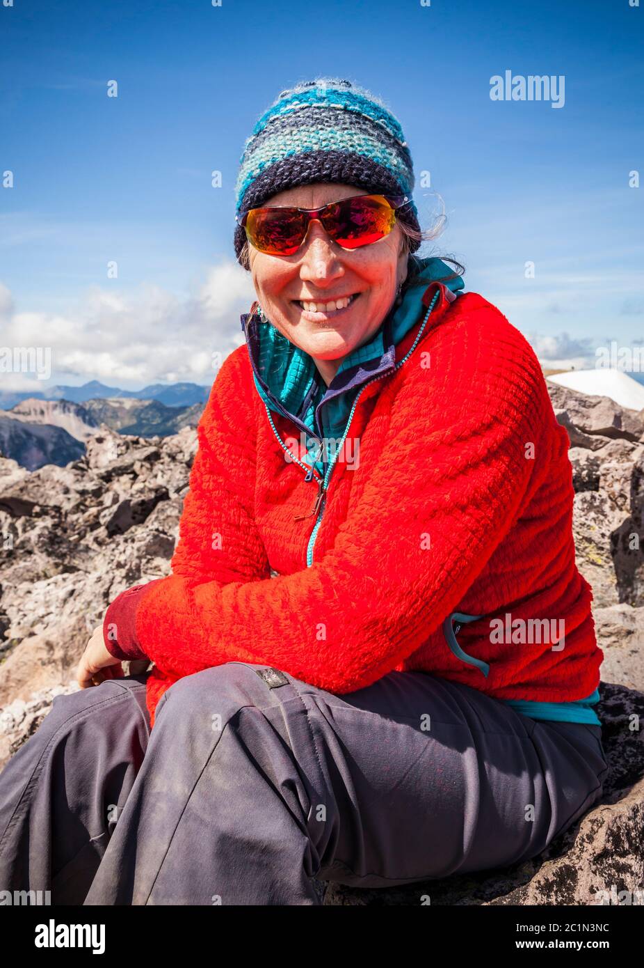 A middle aged woman sitting on top of 3rd Burroughs mountain in Mount Rainier National Park, Washington, USA. Stock Photo