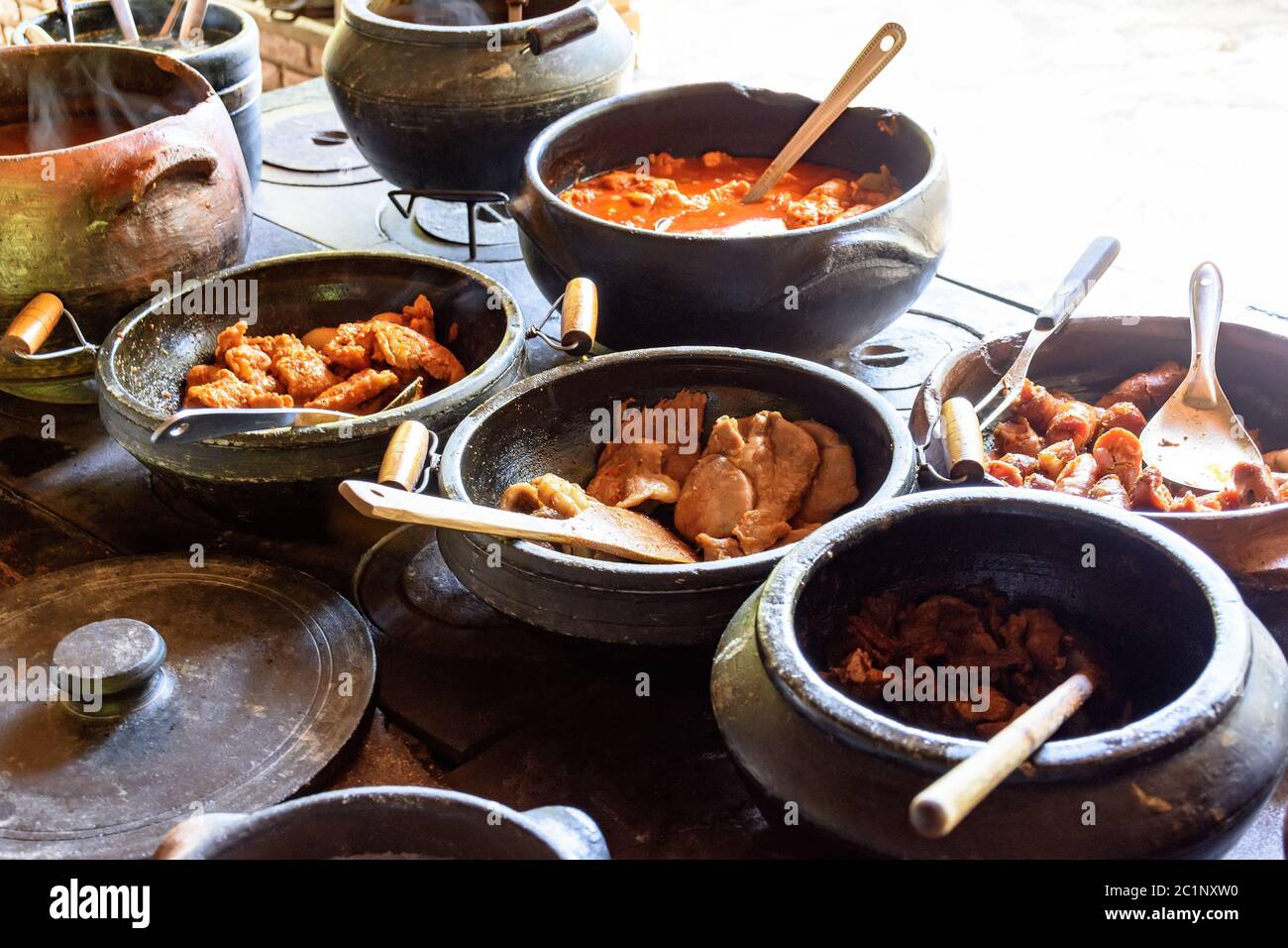 Wood burning stove with traditional brazilian food on clay pots Stock