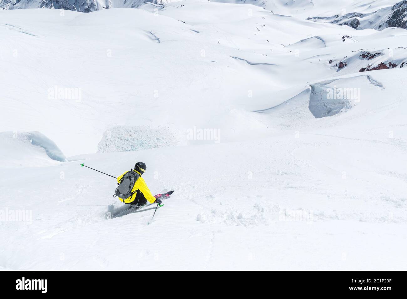 A skier at speed rides on a snowy slope freeride. The concept of winter extreme sports Stock Photo
