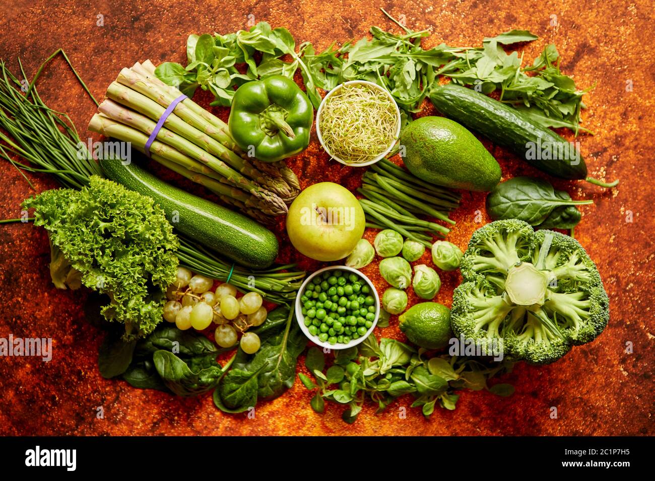 Fresh green vegetables and fruits assortment placed on a rusty metal