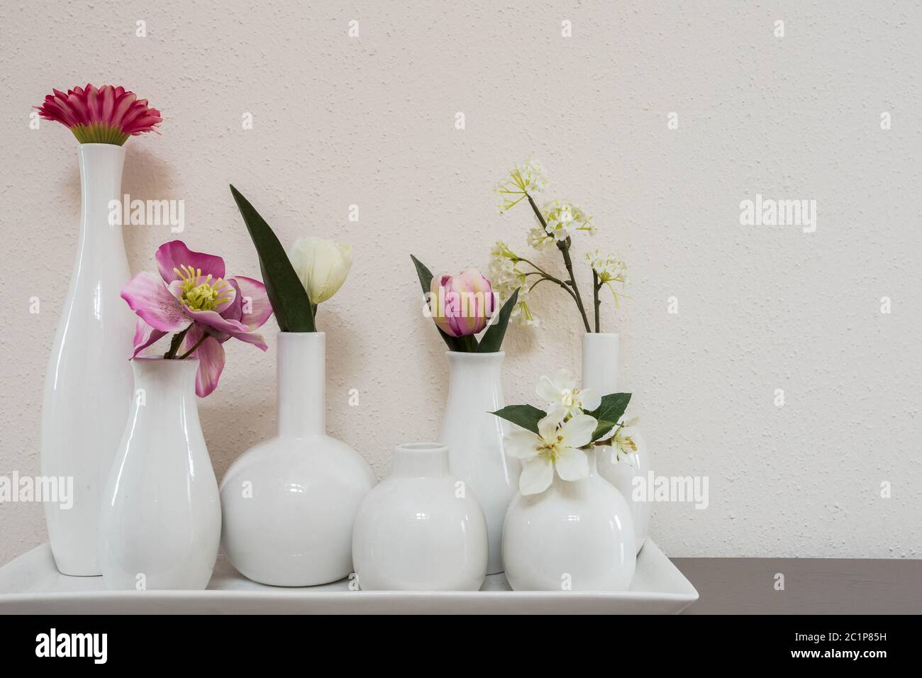 different pink flowers in vases on white background Stock Photo - Alamy