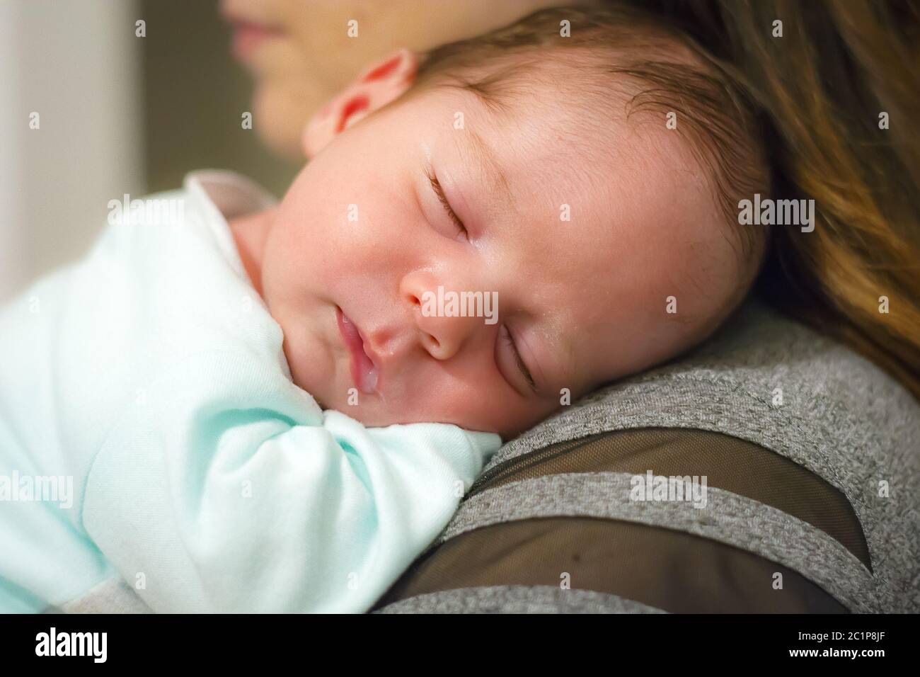 baby sleeping on his mother's shoulder Stock Photo Alamy