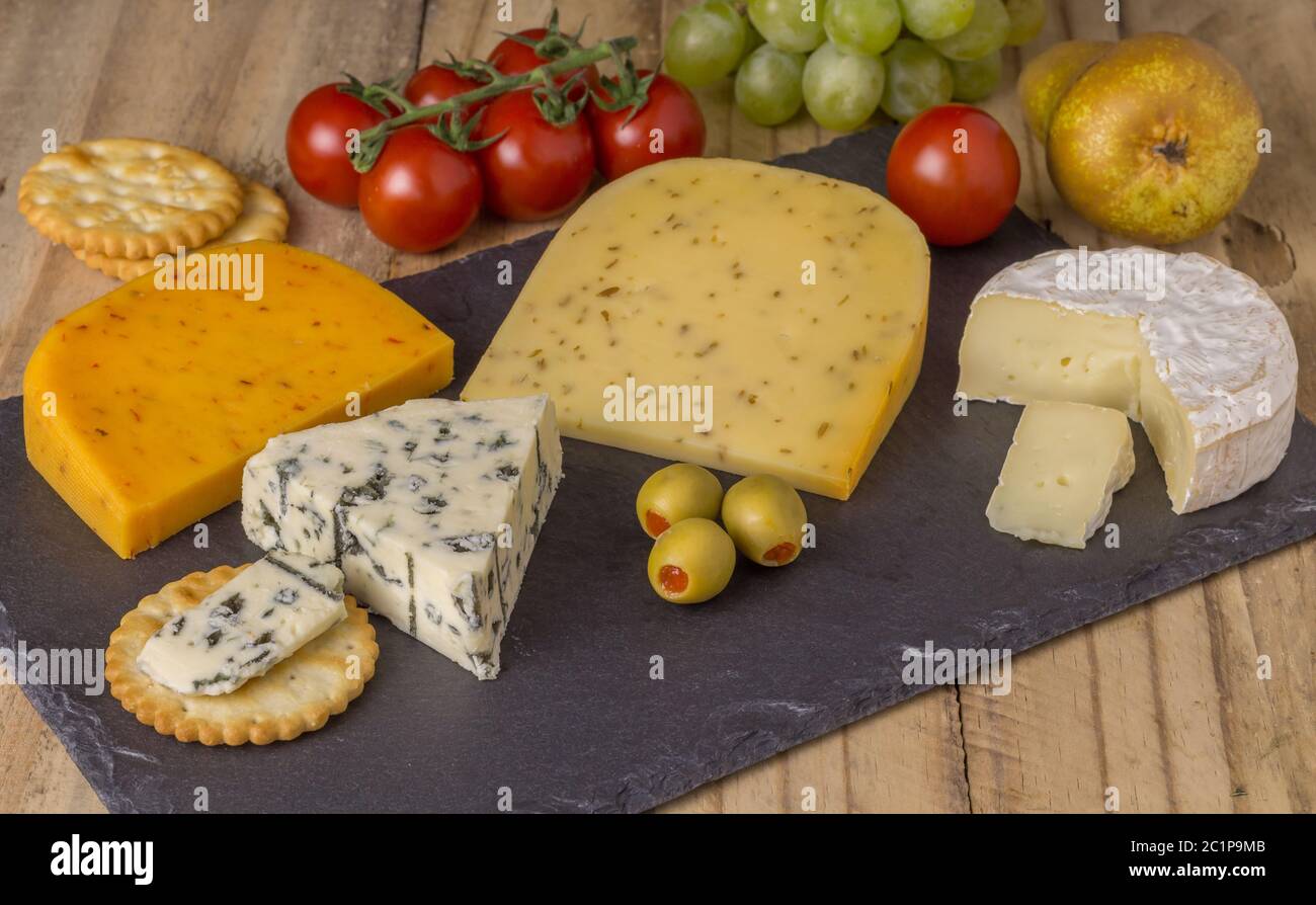 Cheese board with three cheeses, gouda with pimento, gouda with cumin seeds and roquefort blue chees Stock Photo