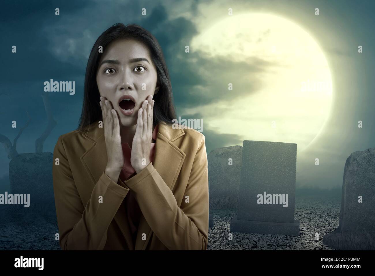 Asian businesswoman scared standing on the graveyard. Halloween concept Stock Photo