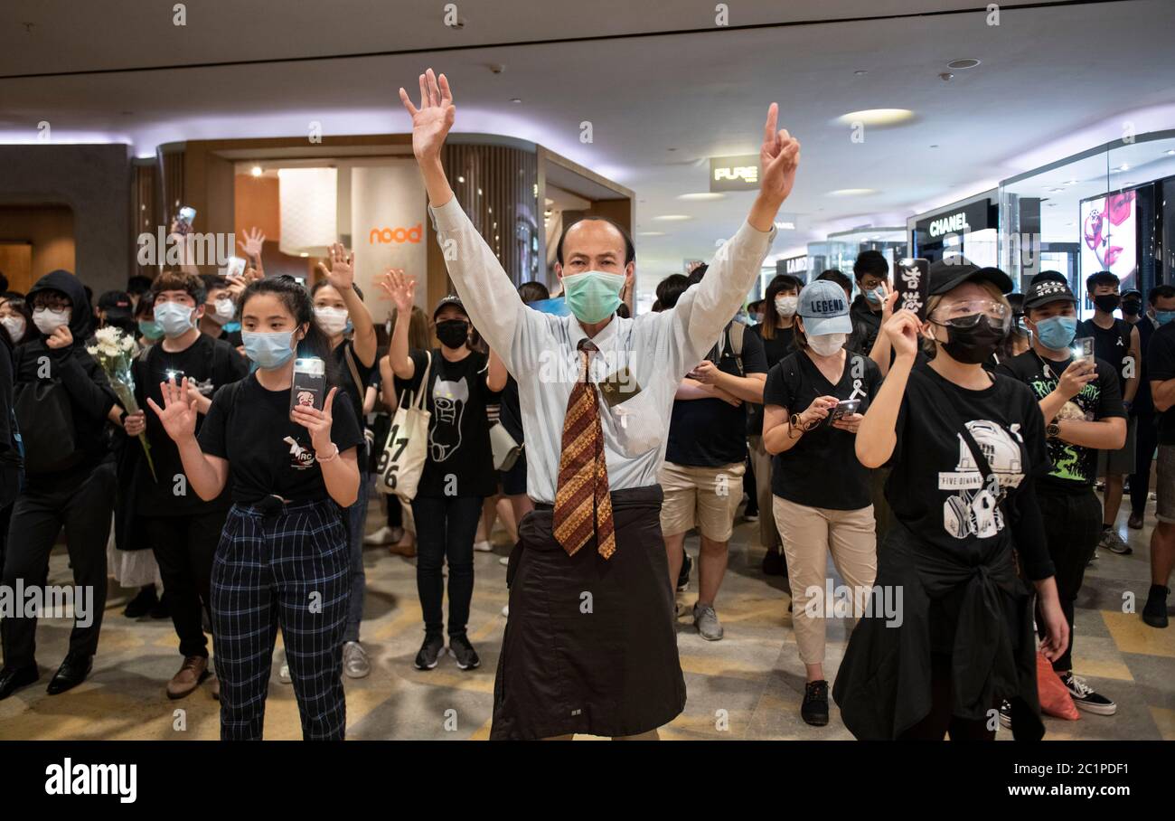 HONG KONG,HONG KONG SAR,CHINA: JUNE 15th 2020. Protesters hold up the “5 demands not one less” hand sign in Pacific Place Mall in Admiralty Hong Kong. They are there to commemorate the first democracy protesters death on one year ago. Marco Leung fell to his death from scaffolding outside the building on 15th June 2019. He became known as the raincoat man.  Alamy Stock Image/Jayne Russell Stock Photo