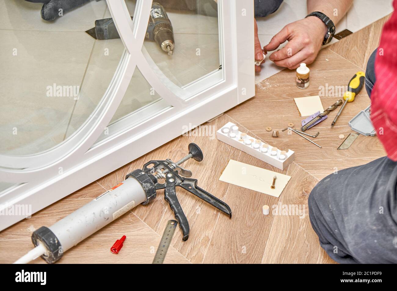 Sliding glass doors repair. Worker install end cap. White sliding glass doors with overlays decor. Close-up Stock Photo