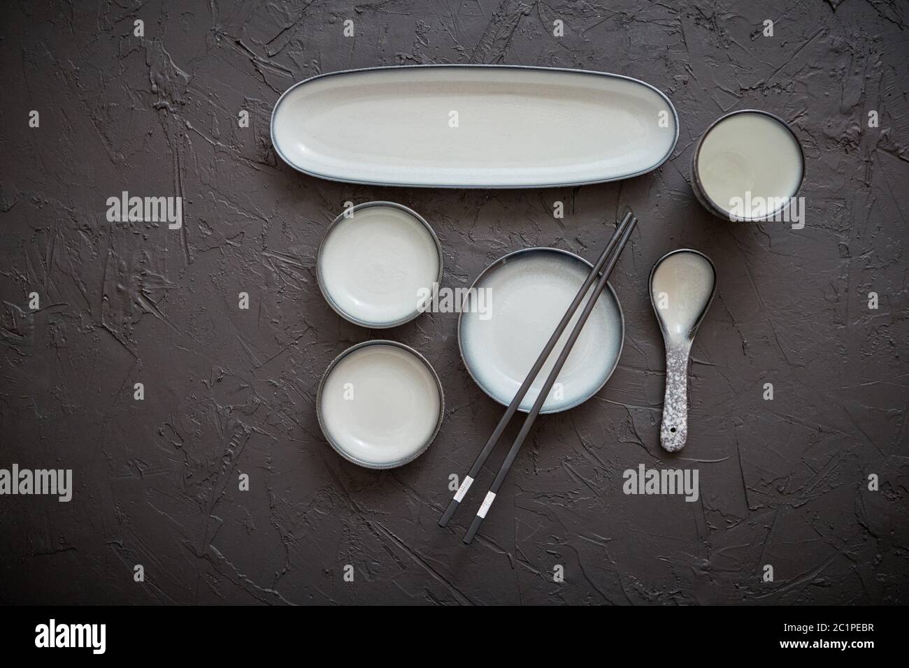Set of empty ceramic dishes for sushi and rolls on a black stone table Stock Photo