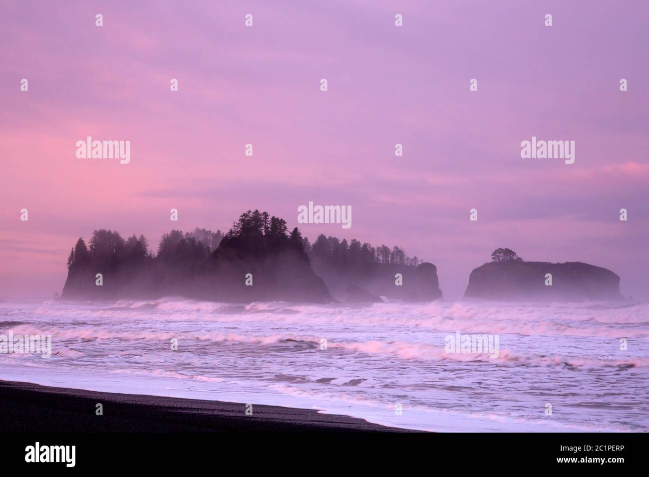 WA16841-00...WASHINGTON - Fog around James Island at sunrise on a stormy day at Rialto Beach in Olympic National Park. Stock Photo