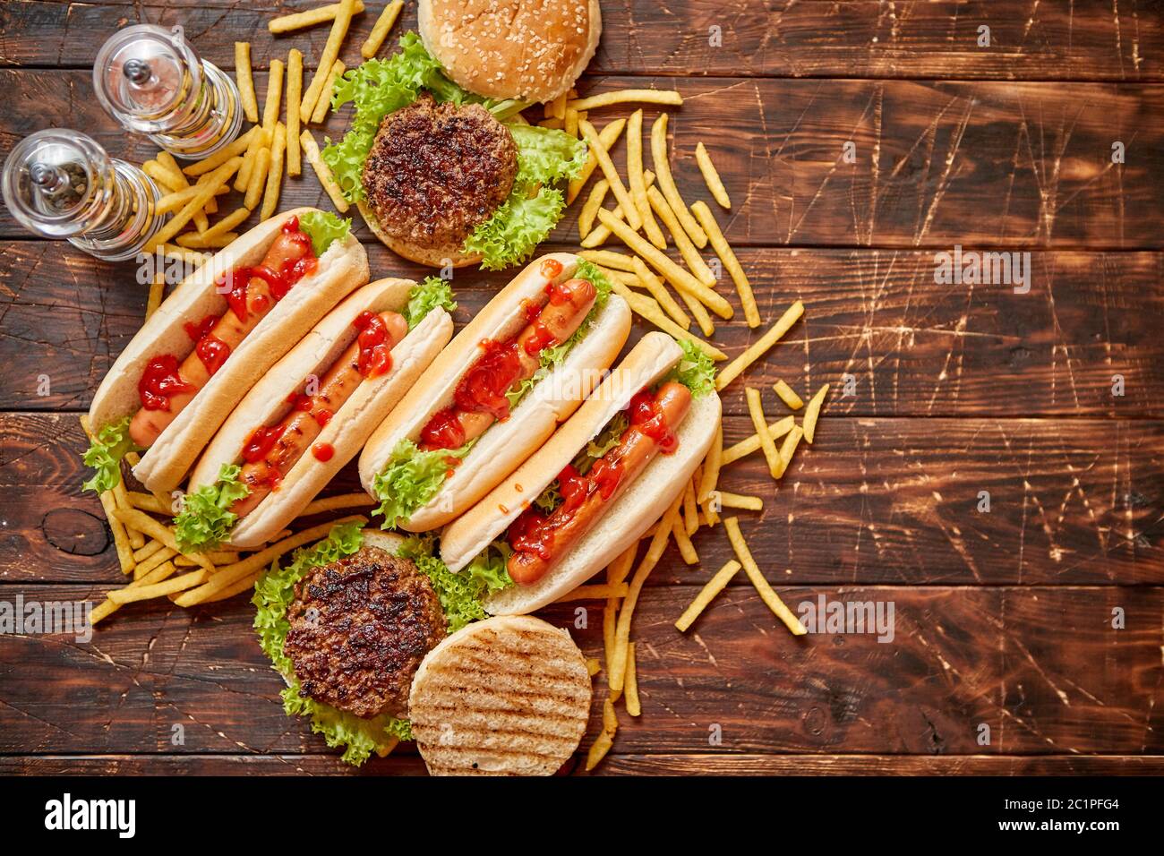 Fastfood assortment. Hamburgers and hot dogs placed on rusty wood table Stock Photo