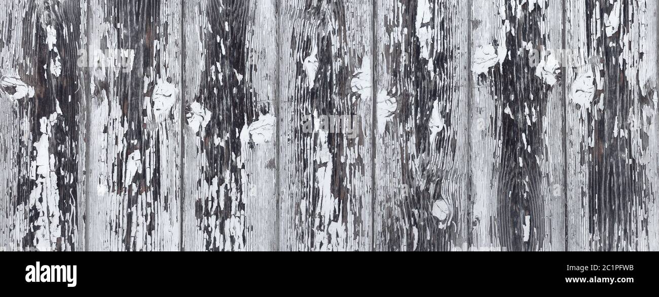 Detail of a heavily weathered gray wooden wall with remnants of white paint Stock Photo