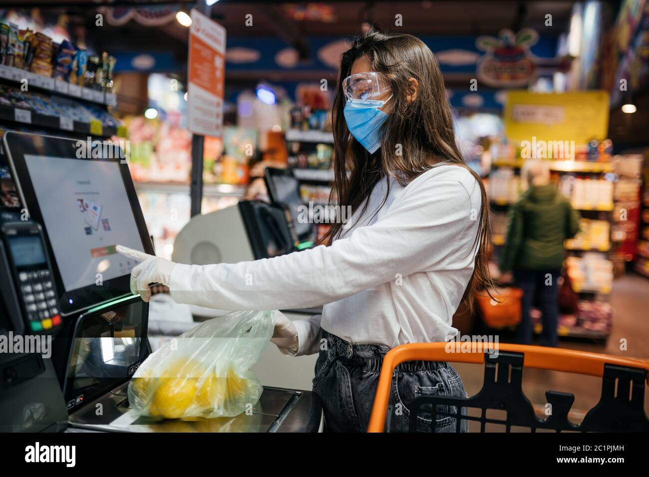 A young woman scans products in a mask and gloves Stock Photo - Alamy