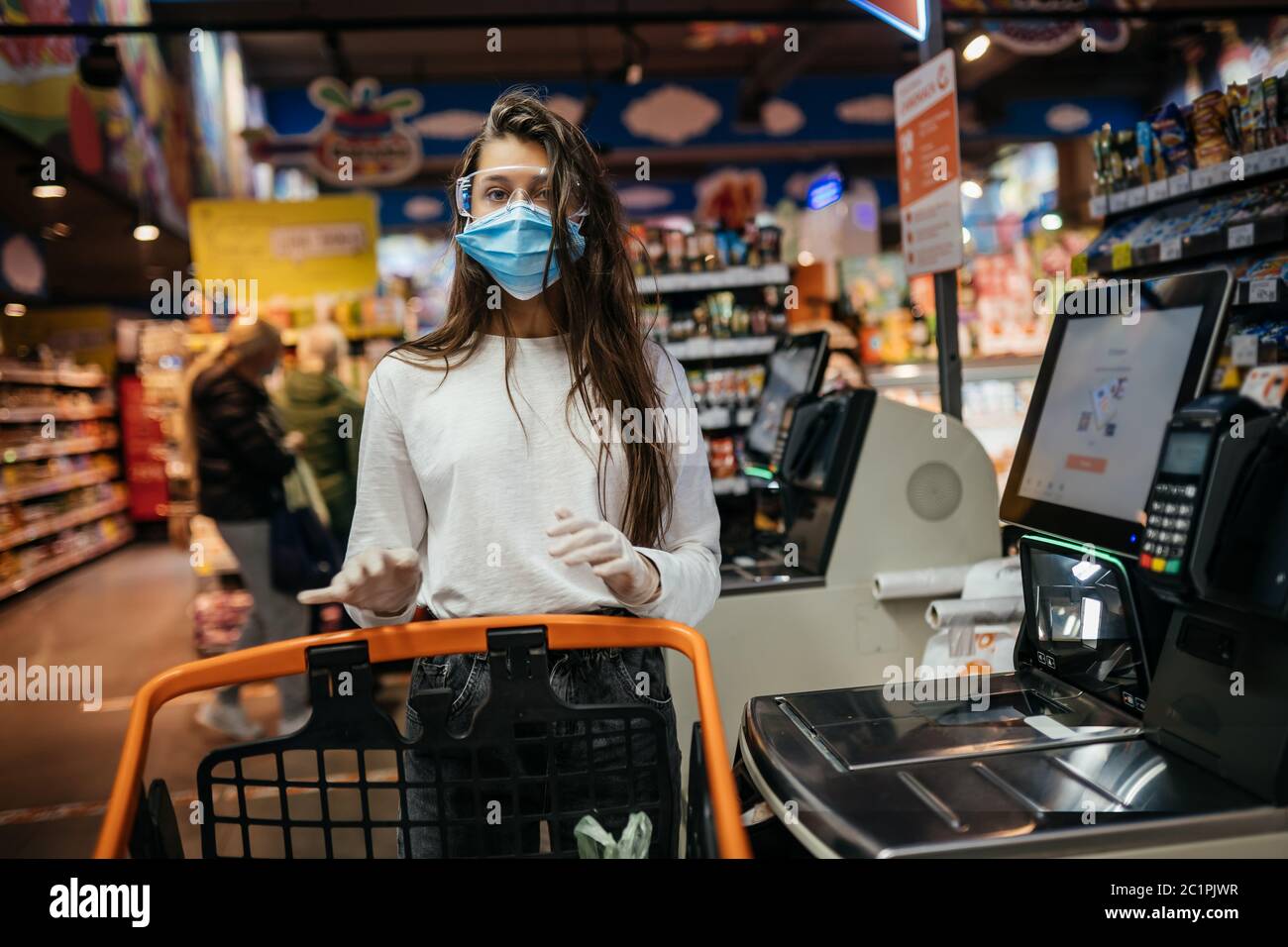 A young woman scans products in a mask and gloves Stock Photo - Alamy