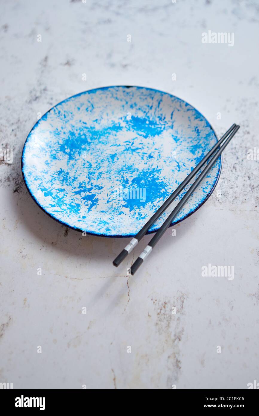 Blue hand painted ceramic serving plate with wooden chopsticks on side