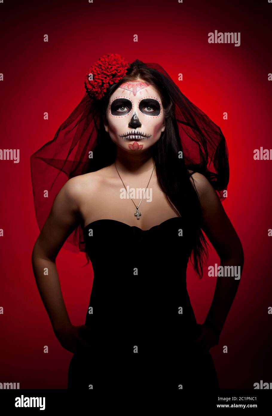 Serious woman in day of the dead mask on red Stock Photo