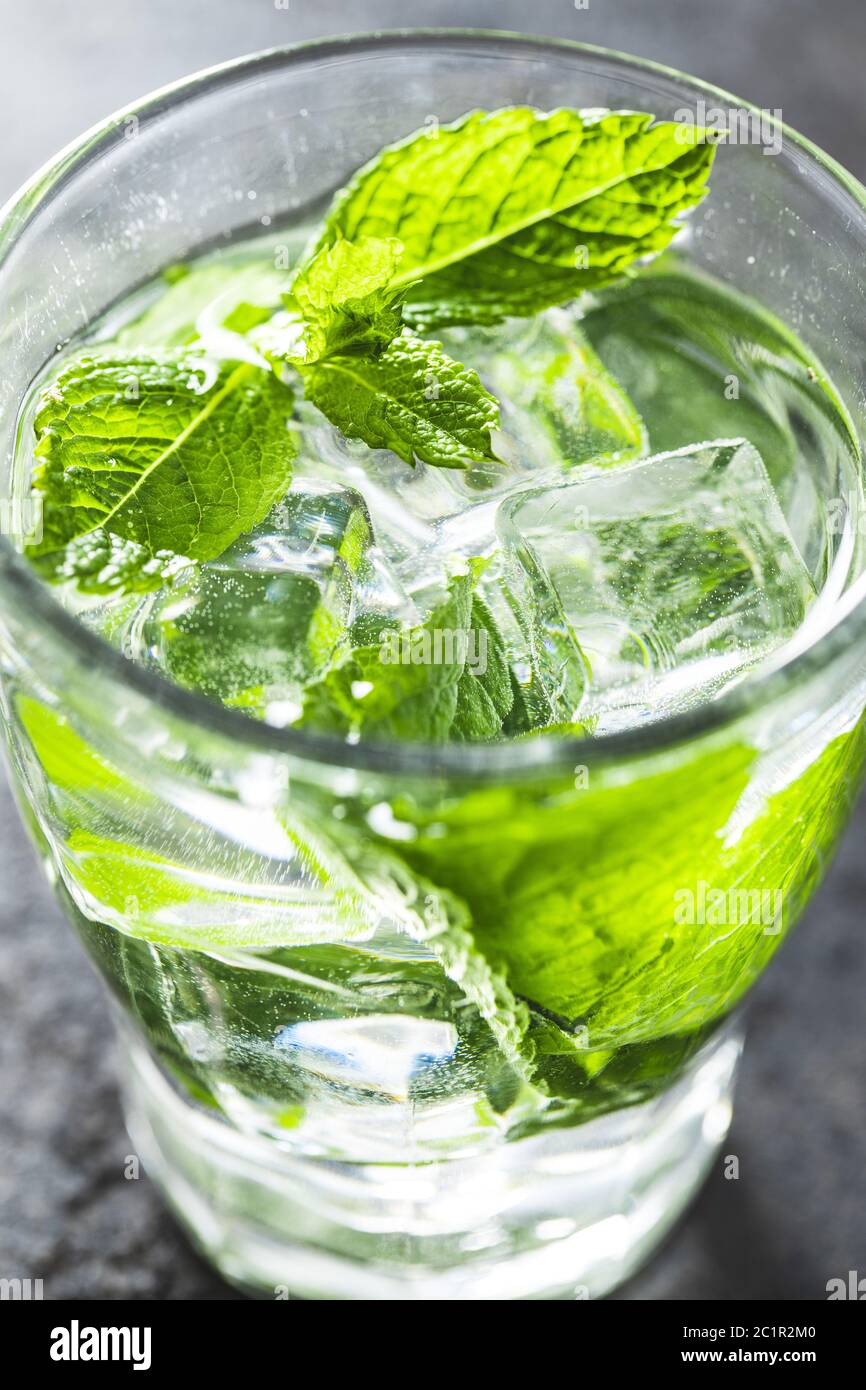 Cool drink with mint leaves and ice cubes on black table Stock Photo
