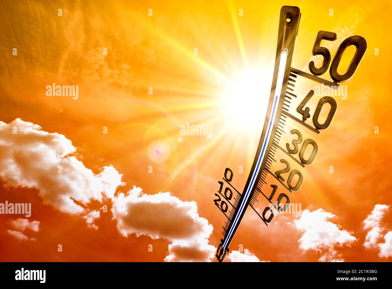 Hot summer or heat wave background, glowing sun on dramatic sky with thermometer Stock Photo