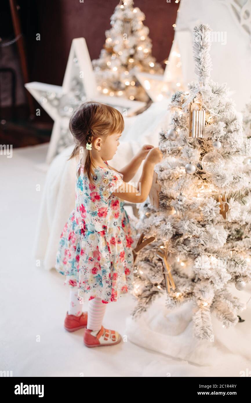 Smiling lovely baby girl in cute dress with lots of christmas presents. Stock Photo