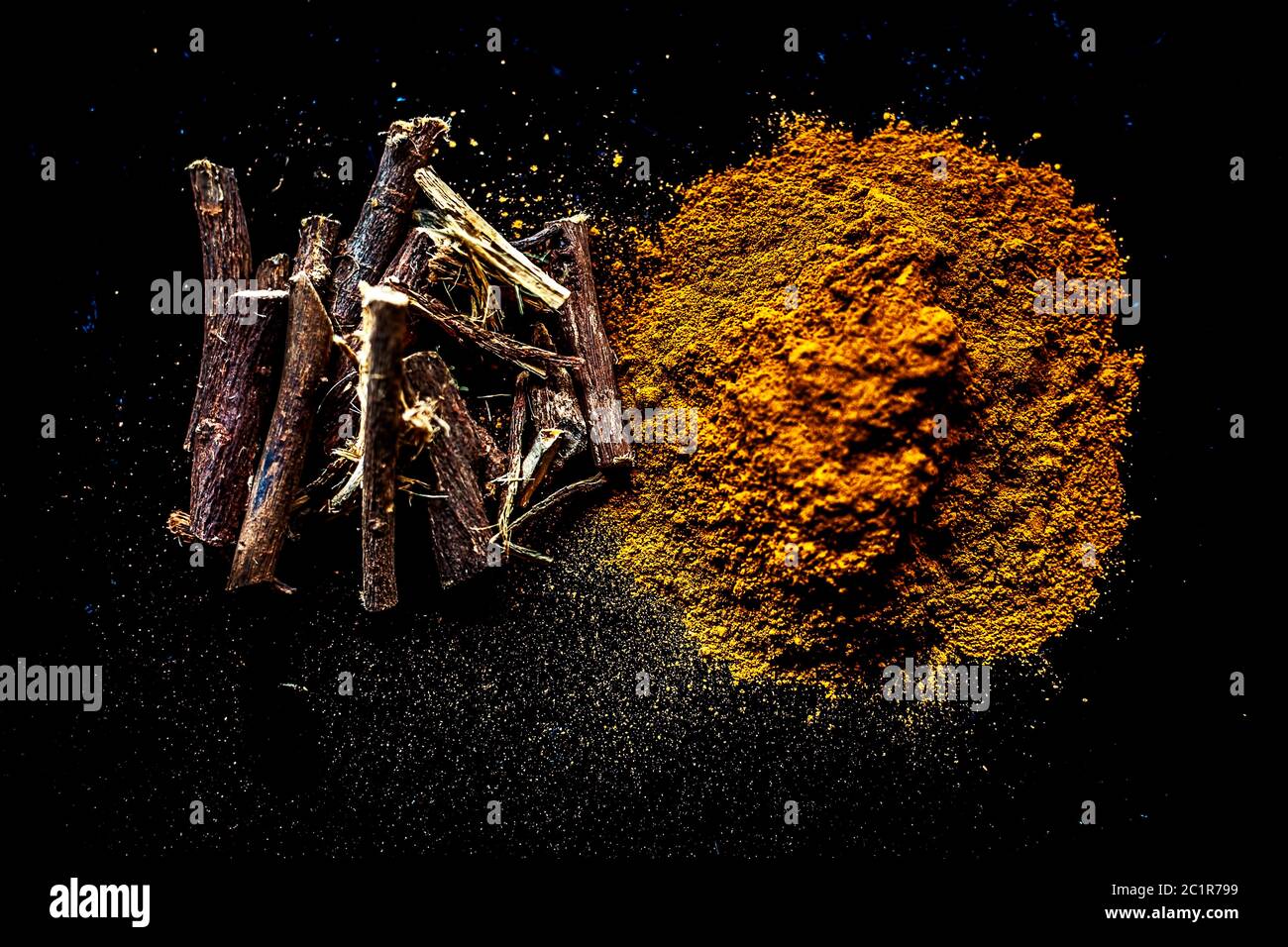 Shot of raw revand chini powder along with its raw root on a wooden surface. Shot in dark gothic colors. Stock Photo
