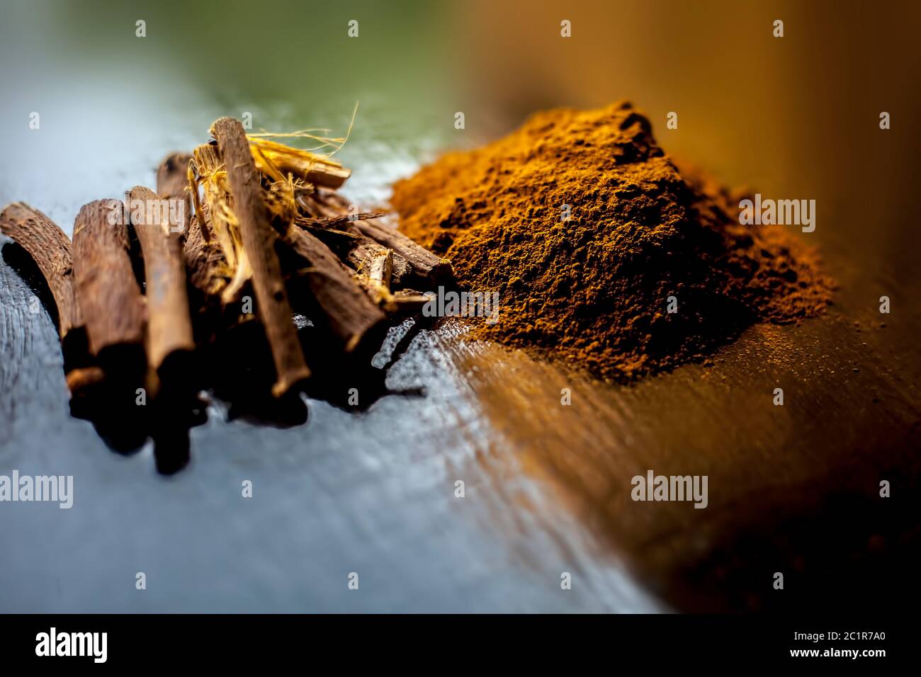 Shot of raw revand chini powder along with its raw root on a wooden surface. Shot in dark gothic colors. Stock Photo
