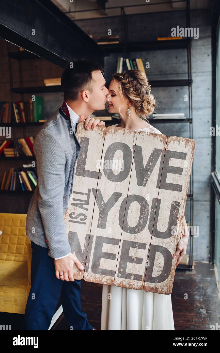 Loving couple kissing holding signboard all you need is love. Stock Photo