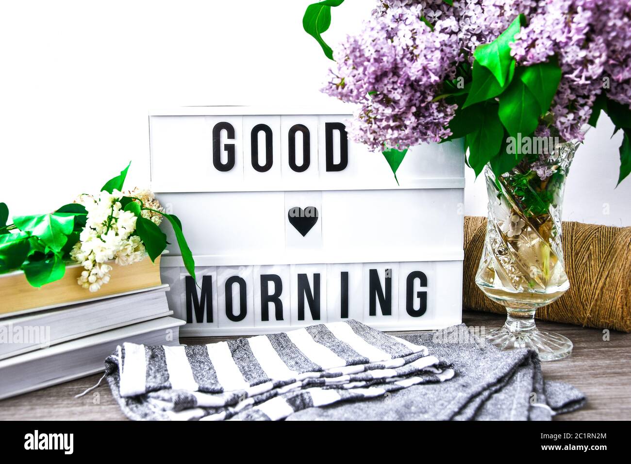 Lightbox with text GOOD MORNING and bouquet of violet lilac flowers in  glass vase, spring time, books and rope Stock Photo - Alamy, image size:1300x956