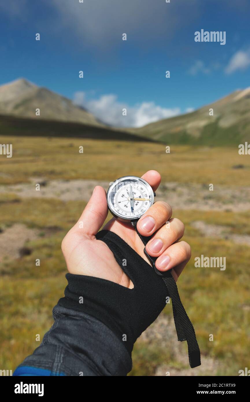 Viewpoint shot. A first-person view of a man's hand holds a compass ...