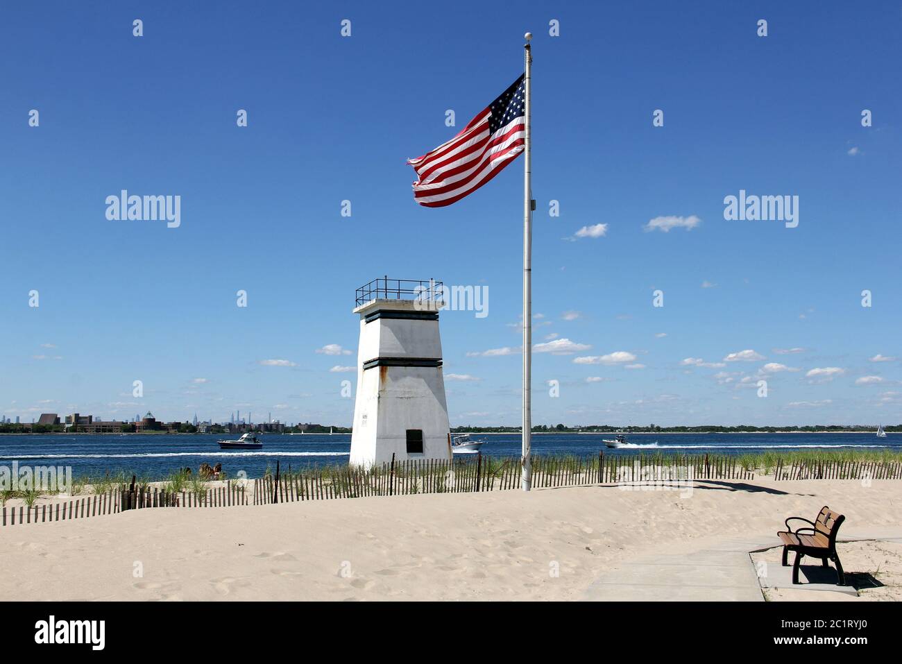 US flag flying on a pole and abandoned watch tower on the beach at