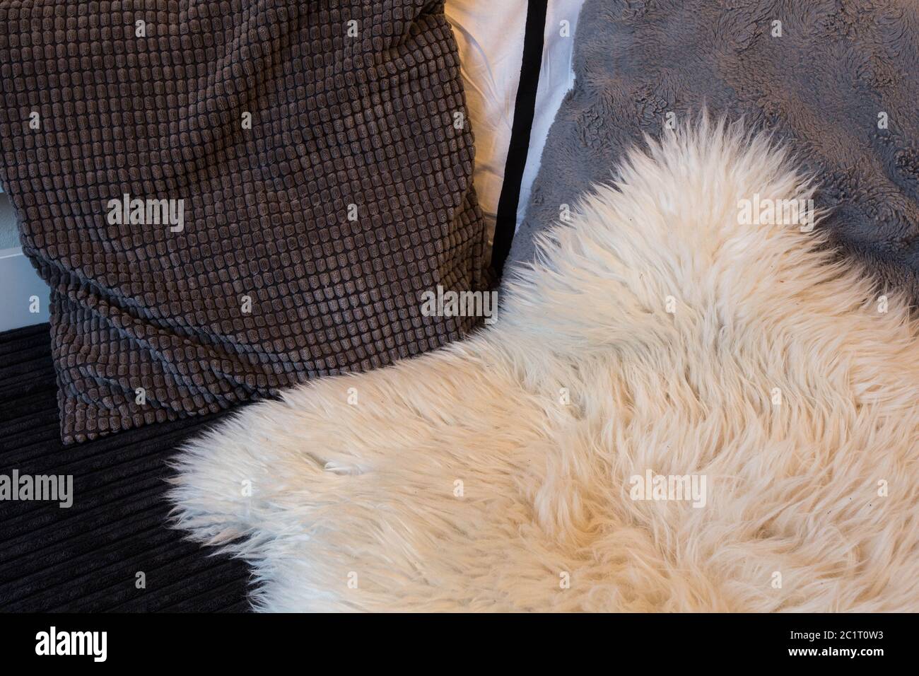 Grey pillows on sofa close up with wool blanket Stock Photo