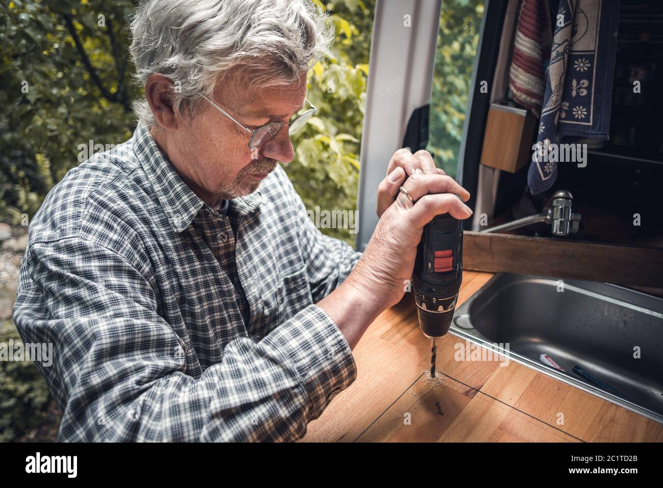 Senior man using a power drill Stock Photo