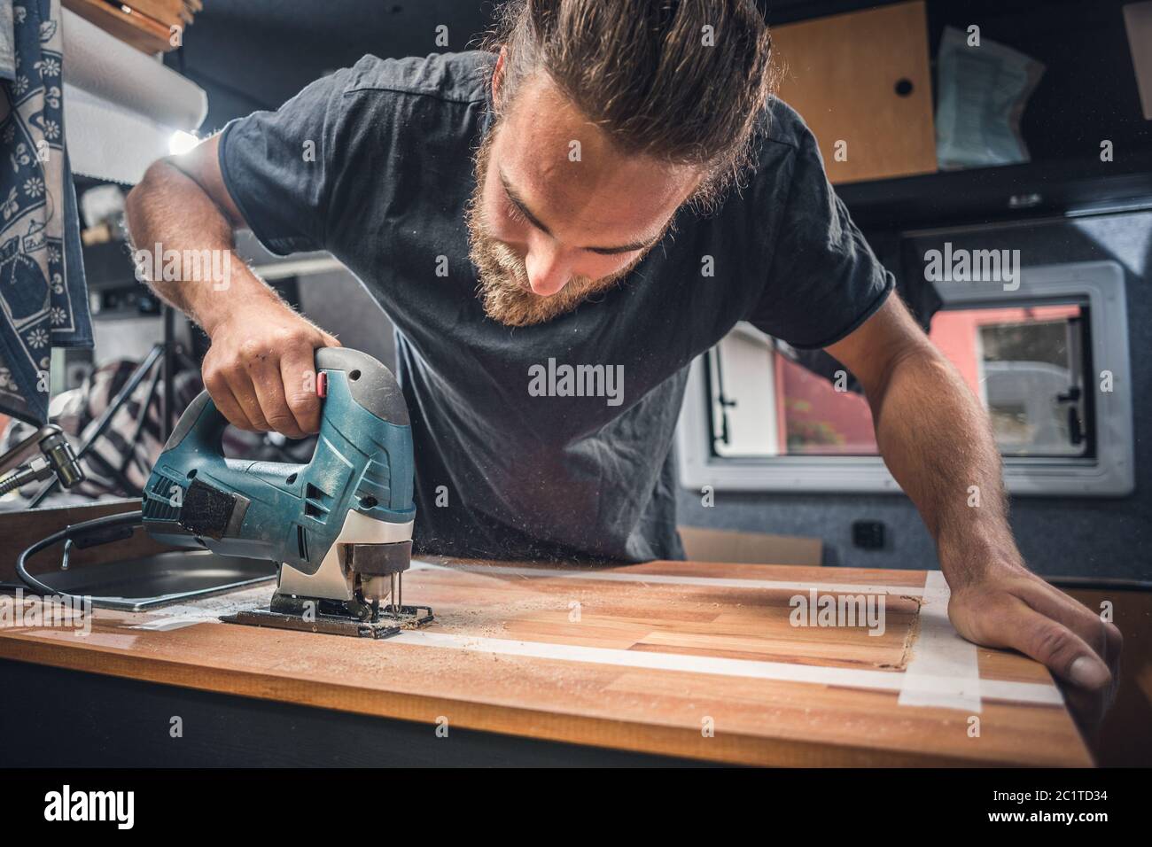 Man working on the countertop inside a camper van Stock Photo