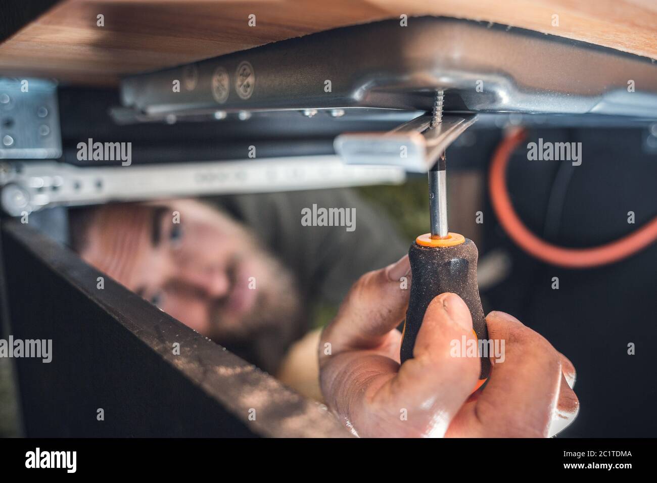 Man using a small screwdriver in a confined space Stock Photo Alamy