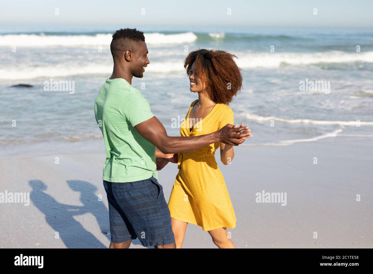 Mixed race couple dancing on the beach Stock Photo